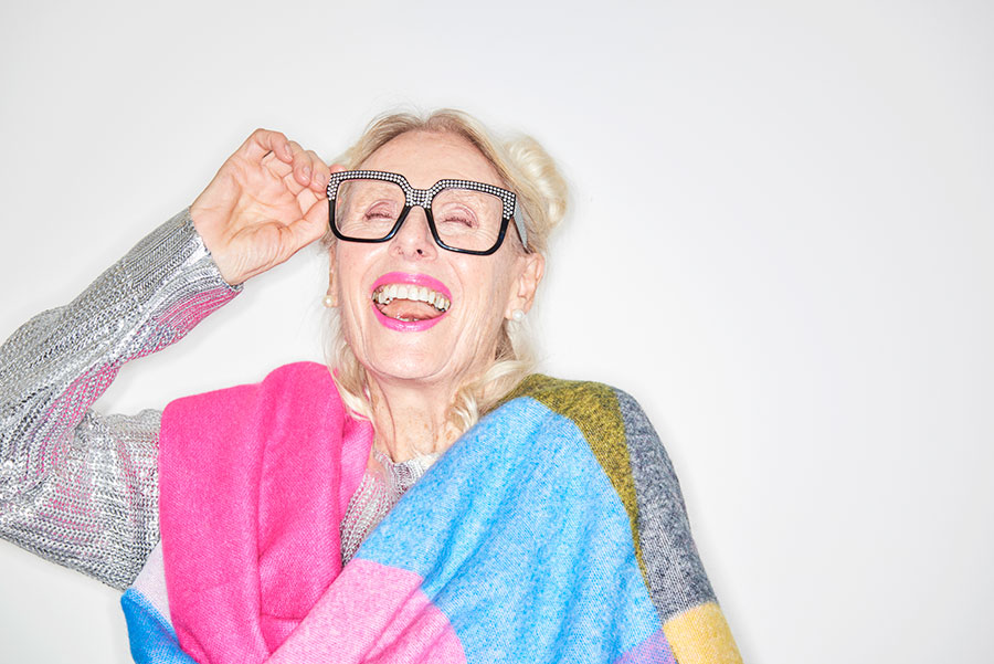 Äldre kvinna med ett leende och glittriga kläder